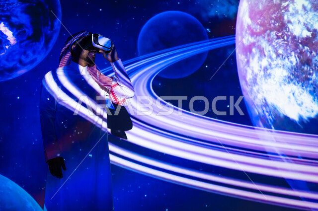 الاهتمام بقطاع الفضاء في المملكة العربية السعودية، رؤية مستقبلية سعودية ٢٠٣٠، التطور الرقمي والتكنولوجي، شاب عربي سعودي خليجي يرتدي الثوب التقليدي يقف بين الكواكب والنجوم ينظر من خلال نظارات الفي ار، خلفية هيولوجرامية ثلاثية الأبعاد للكواكب
