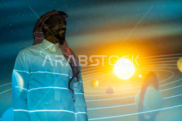 التطور الرقمي والتكنولوجي، رؤية مستقبلية سعودية ٢٠٣٠، دمج العلم بالتكنولوجيا، نمو قطاع الفضاء في المملكة العربية السعودية، شاب عربي سعودي خليجي يرتدي الثوب التقليدي والشماغ يقف أمام حركة الكواكب والنجوم وينظر إلى الأعلى، خلفية هيولوجرامية ثلاثية الأبعاد لحركة الكواكب حول الشمس