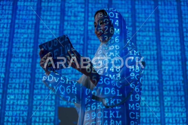 Symbols and software codes that indicate protected data, the use of advanced modern technologies, a veiled Saudi Arabian Gulf woman using a tablet device, scientific and technical development in the Kingdom, integrating science with technology, background laws and mathematical algorithms