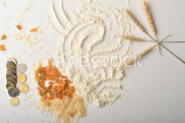 مجموعة من الأرز والزبيب والقمح والطحين والعملات المعدنية على خلفية بيضاء