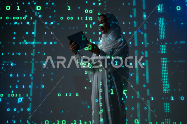 رموز وارقام ولغات برمجية، استخدام التقنيات الحديثة المتطورة، إمرأة عربية خليجية سعودية مبتسمة محجبة تقوم باستخدام جهاز التابلت اللوحي, التطور العلمي و التقني في المملكة، دمج العلم بالتكنولوجيا، خلفية قوانين خوارزميات رياضية