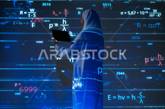 مفهوم التقدم العلمي و التقني، أرقام وحسابات ومعادلات حسابية في مادة الرياضيات، صورة من الخلف لامرأة عربية خليجية سعودية محجبة ترتدي العباءة تمسك بيدها جهاز التابلت المحمول, خلفية للقوانين والمعادلات الرياضية الملونة