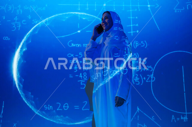 Integrating science with technology, using advanced modern technologies, numbers and calculations in mathematics, a smiling, veiled Saudi Arabian Gulf woman making a phone call via mobile phone, scientific and technical development in the Kingdom, background laws and mathematical algorithms