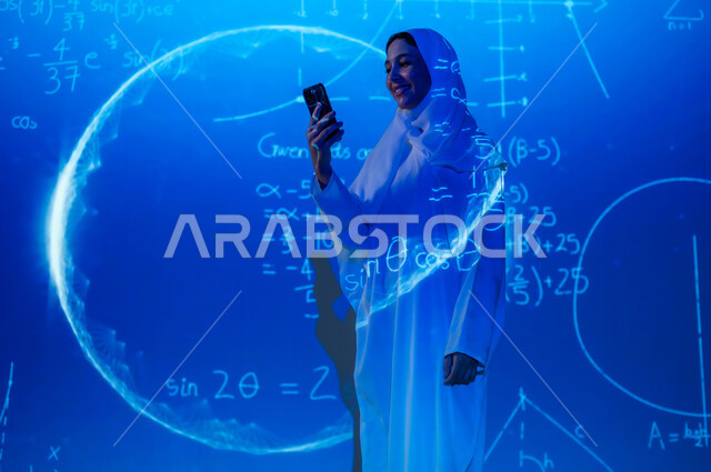 دمج العلم بالتكنولوجيا، استخدام التقنيات الحديثة المتطورة، أرقام وحسابات في مادة الرياضيات، إمرأة عربية خليجية سعودية مبتسمة محجبة ترتدي العباءة تمسك الهاتف المحمول, التطور العلمي و التقني في المملكة، خلفية قوانين خوارزميات رياضية