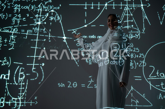 Integrating science with technology, scientific and technical development in the Kingdom, numbers and calculations in mathematics, a smiling Saudi Arabian Gulf woman, veiled and wearing an abaya, looking at the camera with gestures of happiness and pleasure and pointing with her hand to mathematical equations, background laws of mathematical algorithms.