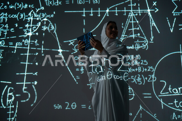 التطور العلمي و التقني في المملكة، دمج العلم بالتكنولوجيا، استخدام التقنيات الحديثة المتطورة، صورة من الخلف لإمرأة عربية خليجية سعودية مبتسمة محجبة ترتدي العباءة تمسك جهاز التابلت وتنظر لشيء ما, أرقام وحسابات في مادة الرياضيات، خلفية قوانين خوارزميات رياضية