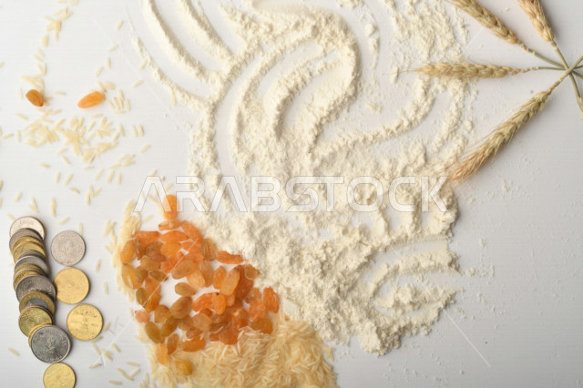 مجموعة من الأرز والزبيب والقمح والطحين والعملات المعدنية على خلفية بيضاء