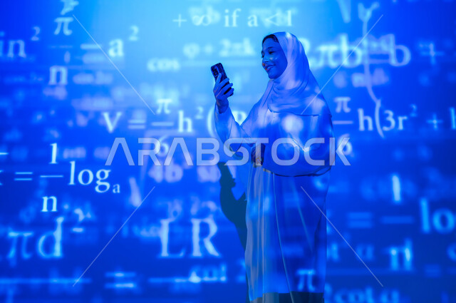 Using advanced modern technologies, numbers and calculations in mathematics, integrating science with technology, a picture from the back of a smiling Saudi Arabian Gulf woman, veiled and wearing an abaya, holding a mobile phone and looking at it, scientific and technical development in the Kingdom, background laws and mathematical algorithms.