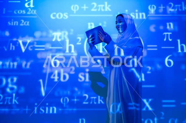 أرقام وحسابات في مادة الرياضيات، دمج العلم بالتكنولوجيا، استخدام التقنيات الحديثة المتطورة، صورة من الخلف لإمرأة عربية خليجية سعودية مبتسمة محجبة ترتدي العباءة تمسك جهاز التابلت وتنظر إليه, التطور العلمي و التقني في المملكة، خلفية قوانين خوارزميات رياضية