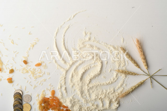مجموعة من الأرز والزبيب والقمح والطحين والعملات المعدنية على خلفية بيضاء