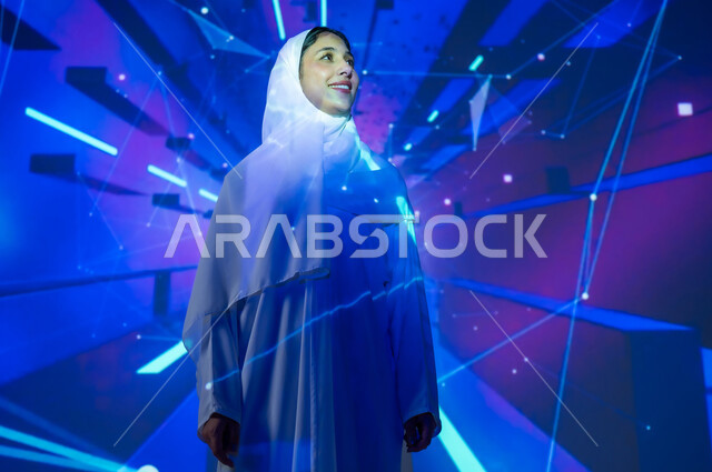 تعزيز مفهوم التطور الرقمي والتكنولوجي في المجتمع السعودي، امرأة عربية خليجية سعودية مبتسمة محجبة ترتدي العباءة تنظر الى شيء ما، خلفية بألوان متنوعة بالتقنية الهيولوجرامية