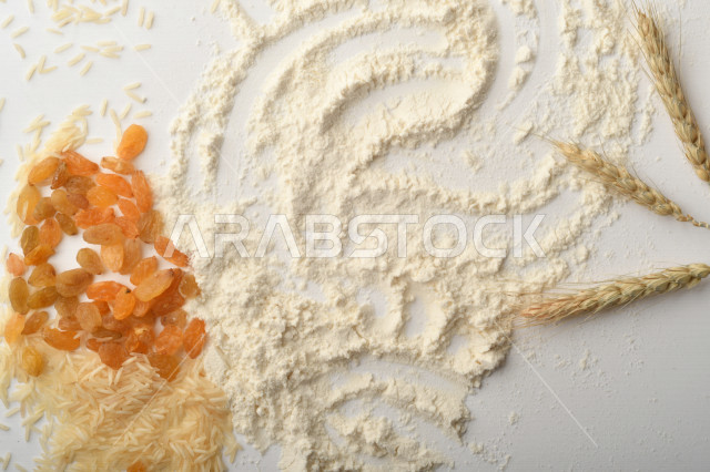 مجموعة من الأرز والزبيب والطحين على خلفية بيضاء