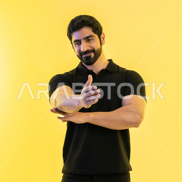 تعابير الترحيب والاستقبال، بورتريه لشاب عربي خليجي اماراتي يرتدي الزي الكاجولل يقوم برفع يده للأعلى، ايماءات إلقاء التحية والسلام الاماراتية، خلفية صفراء