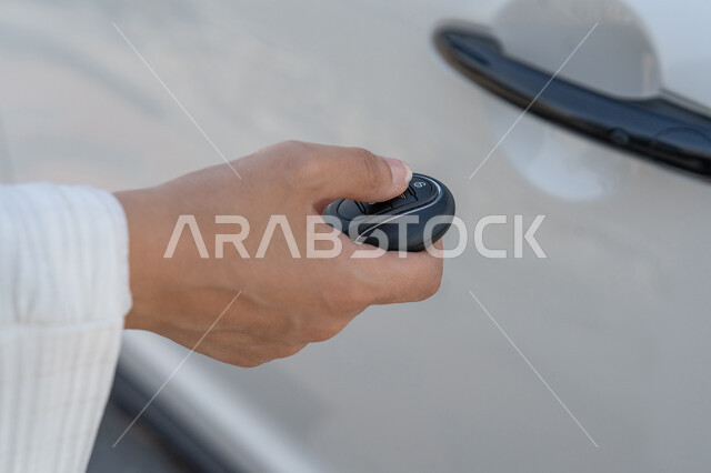 Getting ready to go by car, a close-up photo of the hand of an Emirati Gulf Arab woman holding the electronic car key, opening and closing doors remotely, a young Saudi woman who is proficient in driving, female freedom and independence in Gulf society, the concept of leadership for Arab women