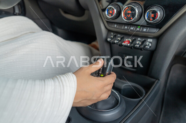 الاعتماد على النفس عند المرأة العربية في التنقل و المواصلات، صورة مقربة ليد إمرأه عربية خليجية إماراتية في سيارتها، حرية القيادة للمرأة الخليجية، سيده سعودية تقوم بالتحكم بسرعة السيارة، مفهوم الاستقلال عند المرأة العربية الخليجية