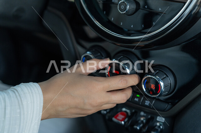 الاستقلال والاعتماد على النفس عند المرأة العربية في التنقل و المواصلات، صورة مقربة ليد إمرأه عربية خليجية إماراتية في سيارتها، حرية القيادة للمرأة الخليجية، سيده سعودية تقوم بالتحكم ببعض الأزار في السيارة