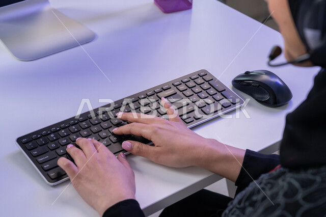الإجابة على أسئلة العملاء، مساهمةالنساء في الوظائف المكتبية، مفهوم العمل في مجال خدمة الزبائن، استخدام الأجهزة التقنية الحديثة، بورتريه مقرب لأيدي موظفة عربية خليجية اماراتية تجلس في المكتب تقوم باداء المهام اليومية