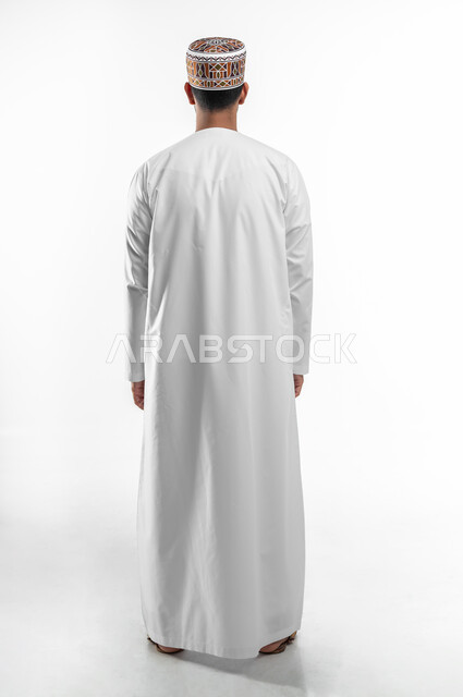 إيماءات تدل على الوقوف بإستقامة وثقة, بورتريه من الخلف لرجل عربي خليجي عماني يرتدي الدشداشة والكمه العمانية، صورة الجسم بالطول الكامل، خلفية بيضاء