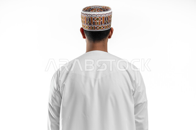 الاهتمام بالمظهر الخارجي, إيماءات تدل على الوقوف بإستقامة وثقة, بورتريه مقرب من الخلف لرجل عربي خليجي عماني يرتدي الدشداشة والكمه العمانية، خلفية بيضاء