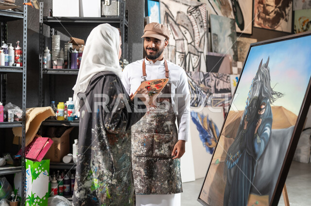The concept of talent and creativity, combining appropriate colors to complete drawings, an exhibition of drawings and paintings in Saudi Arabia, two Saudi Gulf Arab painters cooperating to complete a successful artistic project, an artistic workshop