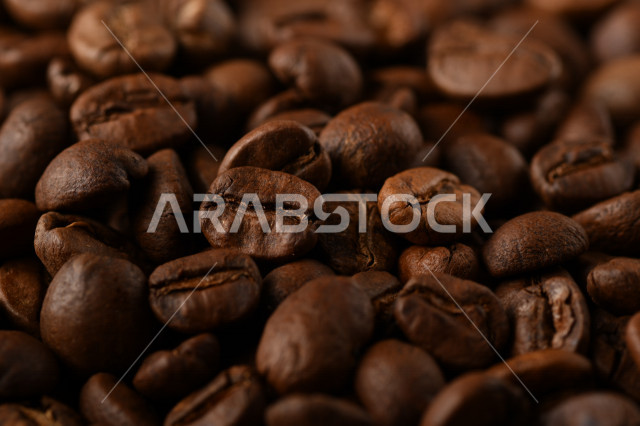تناثر حبوب البن المحمصة على خلفية داكنة , حبوب بن القهوة البنية العضوية .