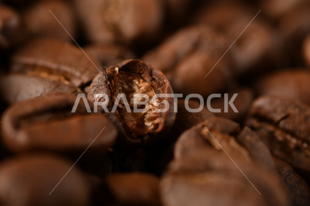 تناثر حبوب البن المحمصة على خلفية داكنة , حبوب بن القهوة البنية العضوية .