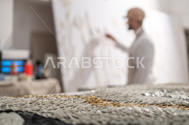 ورشة عمل فنية , إنشاء تصاميم إبداعية بالجبس الأبيض , استخدام الأدوات المناسبة لإنجاز مشروع فني ناجح , ممارسة هواية الرسم الجداري ثلاثي الأبعاد , رسام عربي خليجي سعودي يرتدي الثوب التقليدي و مريلة الرسم , الشغف بالفنون اليدوية