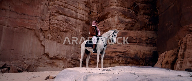 ممارسة هواية ركوب الخيل وشغف الفروسية، رجل عربي خليجي سعودي يركب على ظهر جواد عربي أصيل، توارث حب الخيول من الأجداد ونشره بين أبناء الوطن، إمتطاء الحصان على الرمال الناعمة في المناطق الصحراوية، التكوينات والتشكيلات الصخرية في صحراء السعودية