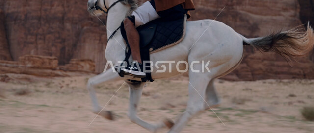 تشكيلات وتكوينات صخرية في صحراء السعودية، اتباع تقاليد الأجداد برعاية وتربية الجياد، التجول في الطبيعة الصحراوية على ظهر الحصان، علاقة أبناء الوطن بالخيل السعودي الأصيل، ممارسة هواية ركوب الخيل، صورة مقربة لرجل عربي خليجي سعودي يمتطي فرس