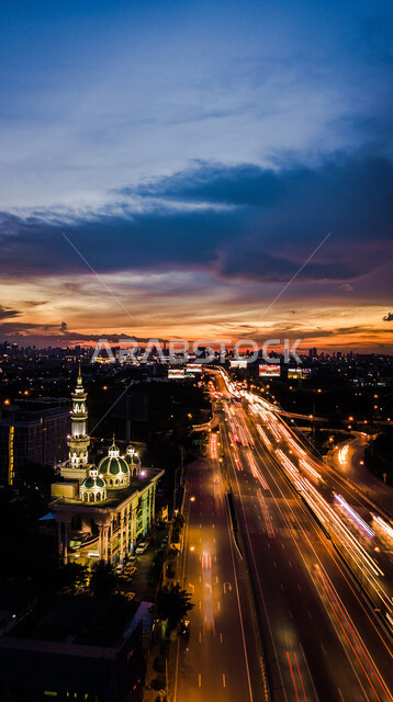  منظر السماء الملبدة بالغيوم، طريق اسفلتي عام، حركة مرور السيارات في طرق جدة في المملكة العربية السعودية، معالم سياحيه مشهورة، التقدم والتطور العمراني للأبراج وناطحات السحاب، العمارات والأبنية في شوارع مدينة جدة المضيئة ليلا