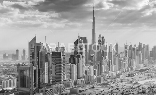 الفن الهندسي المعماري للمباني والمنشآت السكنية والتجارية، منظر السماء بالغيوم الملبدة، برج خلفية في دبي، التوسع والتقدم العمراني في دولة الإمارات العربية المتحدة، صورة بالأبيض والأسود للأبراج وناطحات السحاب