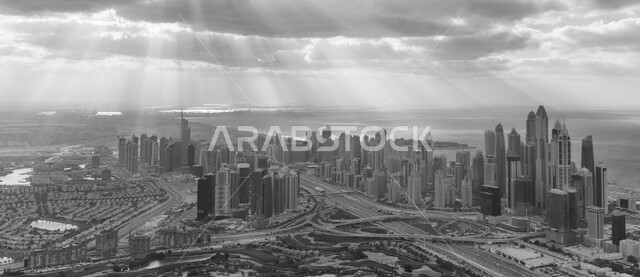 التوسع والتقدم العمراني في دولة الإمارات العربية المتحدة، صورة بالأبيض والأسود للأبراج وناطحات السحاب، برج خلفية في دبي، الفن الهندسي المعماري للمباني والمنشآت السكنية والتجارية، منظر السماء بالغيوم الملبدة