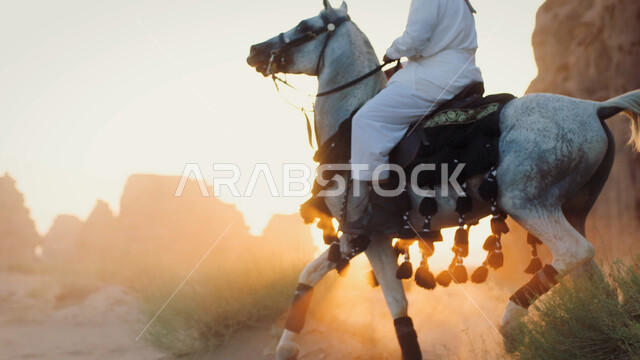 علاقة أبناء الوطن بالخيل الأصيل، توارث حب الجياد من الأجداد إلى الأبناء، التشكيلات والتكوينات الصخرية الطبيعية في صحراء السعودية، صورة مقربة لرجل عربي خليجي سعودي يمتطي الفرس، التجول في الطبيعة الصحراوية على ظهر الحصان