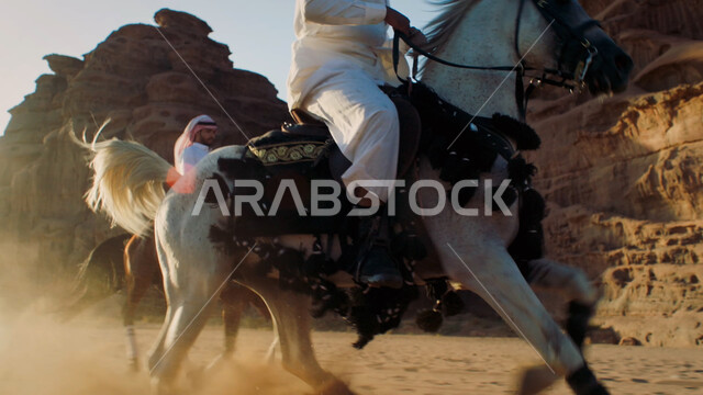ممارسة هواية ركوب الخيل، توارث حب الجياد من الأجداد إلى الأبناء، التشكيلات والتكوينات الصخرية الطبيعية في صحراء السعودية، صورة مقربة لرجل عربي خليجي سعودي يمتطي الفرس، التجول في الطبيعة الصحراوية على ظهر الحصان