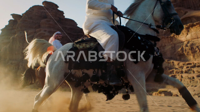 التجول في الطبيعة الصحراوية على ظهر الحصان، ممارسة هواية ركوب الخيل، توارث حب الجياد من الأجداد إلى الأبناء، التشكيلات والتكوينات الصخرية الطبيعية في صحراء السعودية، صورة مقربة لرجل عربي خليجي سعودي يمتطي الفرس