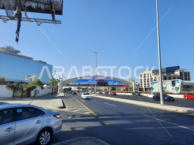 حركة مرور السيارات في الطرقات والشوارع المعبدة، جسر المشاة فوق شارع الاندلس في مدينة جدة في المملكة العربية السعودية، اعمدة الانارة على اطراف الطريق الاسفلتي العام، الاهتمام بالبنية التحتية