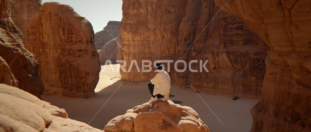 مناطق الرحلات وقضاء الوقت الممتع, أماكن ومعالم السياحة المشهورة, صورة من الخلف لشاب عربي خليجي سعودي يتأمل الطبيعة الجبلية في المملكة العربية السعودية, التكوينات والتشكيلات الصخرية, التضاريس في القمم والمرتفعات الجبلية, الاستمتاع بالمناظر الطبيعية