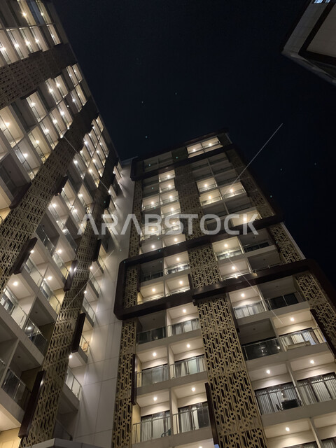 الفن الهندسي المعماري على الطراز الحديث، صورة مقربة لمبنى مرتفع مضيء ليلا، النمو والتقدم العمراني للأبراج وناطحات السحاب في المملكة العربية السعودية