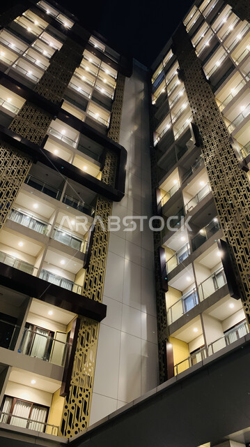 Modern architectural engineering art, close-up of a high-rise building illuminated at night, growth and urban progress of towers and skyscrapers in the Kingdom of Saudi Arabia