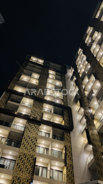 الفن الهندسي المعماري على الطراز الحديث، صورة مقربة لمبنى مرتفع مضيء ليلا، النمو والتقدم العمراني للأبراج وناطحات السحاب في المملكة العربية السعودية