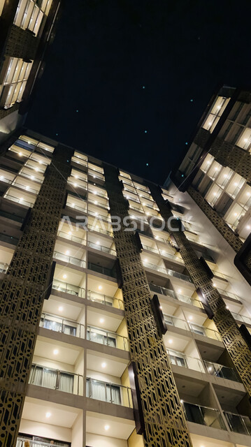 الفن الهندسي المعماري على الطراز الحديث، صورة مقربة لمبنى مرتفع مضيء ليلا، النمو والتقدم العمراني للأبراج وناطحات السحاب في المملكة العربية السعودية