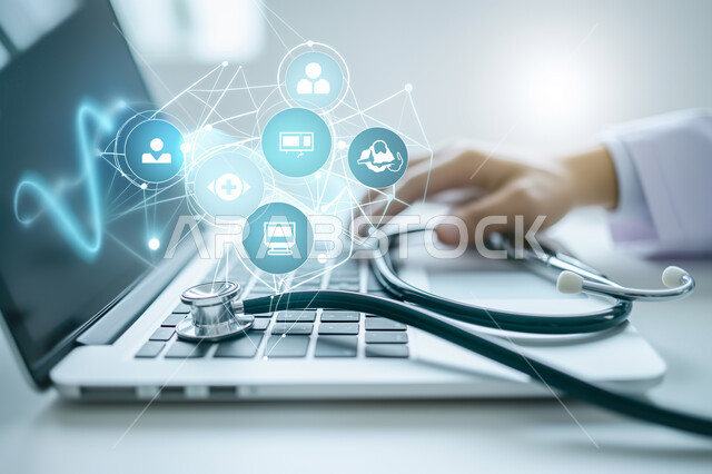 رموز رقمية هولوجرامية لأيقونات الكمبيوتر وشبكات الإنترنت، التطور الالكتروني والنمو التكنولوجي، صوة مقربة لأيدي طبيبة عربية خليجية سعودية تستخدم الحاسب المحمول مع سماعة طبية، التكنولوجيا الرقمية الحديثة