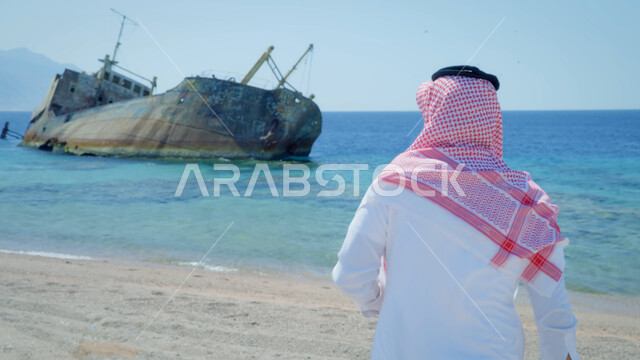 المناظر البحرية الهادئة، مفهوم السياحة في المملكة العربية السعودية, أماكن سياحية ترفيهيه, صورة من الخلف لرجل عربي خليجي سعودي يرتدي الزي التقليدي والشماغ يقف على الشاطئ، خلفية طبيعة بحرية، أمواج البحر الأحمر الهادئة