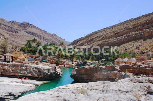 جريان المياه الصافية في وادي بين سلسلة الجبال والتكوينات والتشكلات الصخرية في المناطق الصحراوية، الوديان والقمم الصخرية في البراري، اماكن سياحية مشهورة في المملكة العربية السعودية