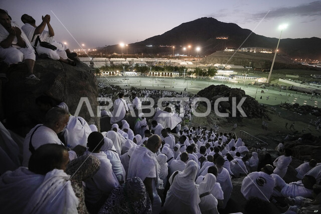 Famous religious landmarks and places, great Islamic feelings, performing Hajj and Umrah rituals in the Kingdom of Saudi Arabia, standing in Arafat, a close-up of the pilgrims of the Sacred House of God on the Mount of Mercy in Mecca at night time, worship and getting closer to God Almighty.