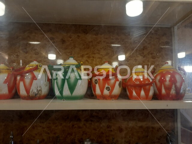 ابريق المشروبات الساخنة, صورة مقربة لمجموعة من اباريق الشاي الملونة في متحف مطير العيش في قرية جرداء بن علي في محافظة الحجرة في منطقة الباحة, أماكن ومعالم سياحية مشهورة في المملكة العربية السعودية, صناعات يدوية شعبية