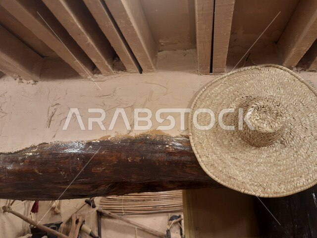 المنشآت التراثية الشعبية, صورة مقربة لقبعة من القش معلقة على جدار طيني, القرى الأثرية في المملكة العربية السعودية, مبنى متحف مطير العيش في قرية جرداء بن علي في محافظة الحجرة في منطقة الباحة, أماكن ومعالم سياحية تاريخية مشهورة