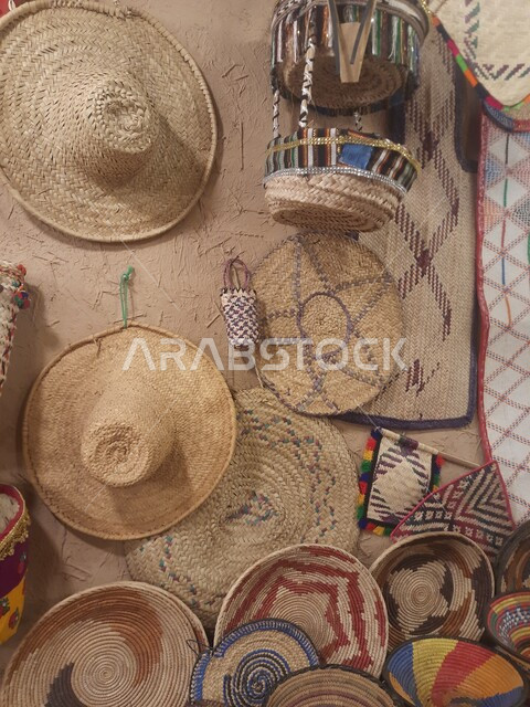 الفخر بالصناعات اليدوية الشعبية, حرف ومهن تقليدية قديمة, مشغولات ومصنوعات من القش وسعائف الخوص, مجموعة من قبعات القش المعلقة في متحف قرية مطير العيش في جرداء بن على في محافظة الحجرة بمنطفة الباحة, السياحة في المملكة العربية السعودية