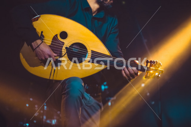  شاب عربي سعودي أنيق يعزف على الجيتار, الغيتار (الجيتار أو القِيثَارَة ) آلة موسيقية وترية بأوتار مدقوقة , عزف الموسيقى الهادئة الراقية