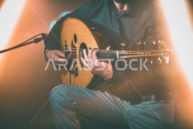  شاب عربي سعودي أنيق يعزف على الجيتار, الغيتار (الجيتار أو القِيثَارَة ) آلة موسيقية وترية بأوتار مدقوقة , عزف الموسيقى الهادئة الراقية